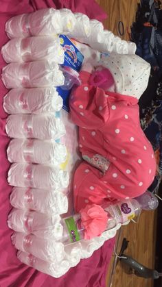 a pile of diapers sitting on top of a bed next to a baby doll