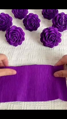 someone is making purple flowers out of fabric