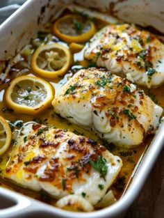 baked fish with lemons and herbs in a casserole dish, ready to be eaten