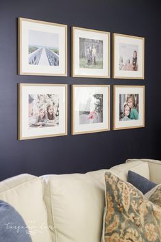 a living room with pictures hanging on the wall and pillows in front of it,