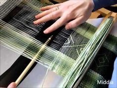 a person is weaving fabric on a loom