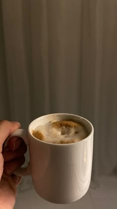 a person holding a cup of coffee in their hand