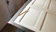 a kitchen with white cabinets and tools on the counter