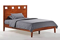 a bed with two pillows on top of it next to a wooden headboard and foot board