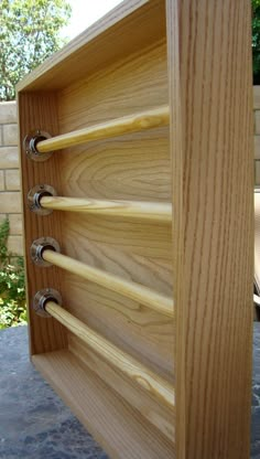 a wooden shelf with four hooks on it