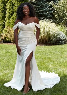 a woman in a white dress standing on grass