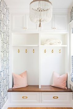 an instagramted photo of two white benches with pink pillows and gold hardware on them