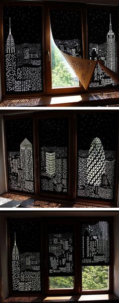 the window is decorated with black and white paper cut out of cityscapes, which are