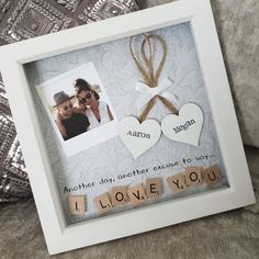 a photo frame with two hearts and the words i love you written in wood letters