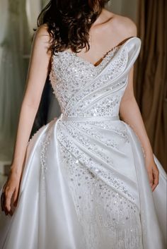 a woman in a white wedding dress is posing for the camera with her hand on her hip