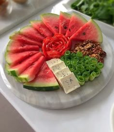 a watermelon and cheese platter is displayed on a table with other food items