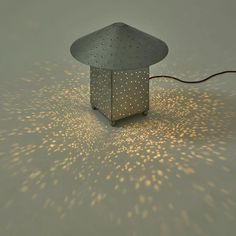 a lamp that is sitting on the floor with some light coming from it's base