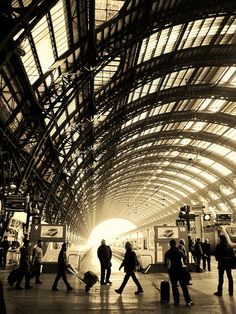 people are walking through the train station with their luggage