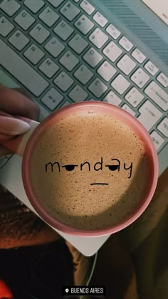 a person holding a coffee cup with the word monday written on it