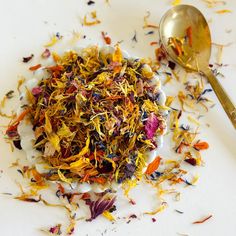 a white plate topped with dried flowers and a spoon