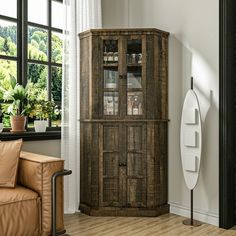 a wooden cabinet sitting next to a window in a living room