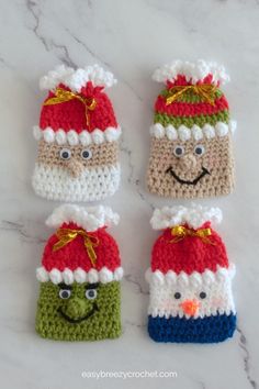 four crocheted santa hats with faces on them