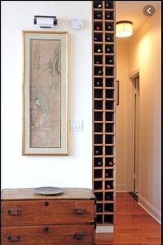 an empty room with a large wine rack in the corner and a painting on the wall