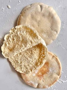 three pita breads sitting on top of a white counter next to each other