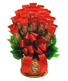 an arrangement of candy bars wrapped in red ribbon