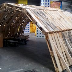 a wooden structure sitting on top of a parking lot next to a yellow fire hydrant