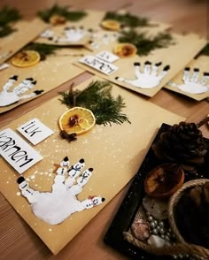 there are many cards with handprints on them and pine cones in the background