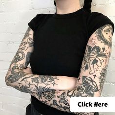 a woman with her arms crossed and tattoos on her arm, standing in front of a white brick wall