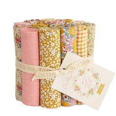 four rolls of paper with floral designs on them and a tag hanging from the side