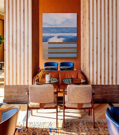 a living room filled with furniture next to a wall covered in vertical striped walls and wooden paneling