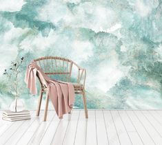 a chair sitting on top of a wooden floor next to a wall covered in clouds