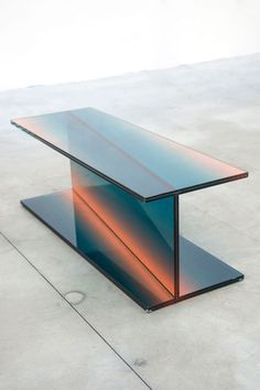 a glass table sitting on top of a cement floor