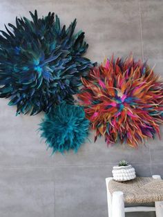 there are two colorful flowers hanging on the wall