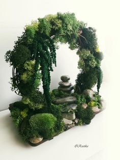 a rock garden with moss and rocks in the shape of a circle on a white surface