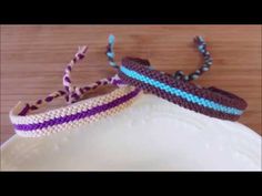 two crocheted bracelets sitting on top of a white plate next to each other