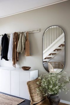 a room with a bunch of clothes hanging on the wall and a mirror above it