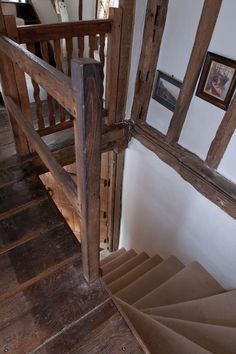 an old wooden stair case with pictures on the wall