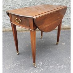 an antique wooden desk with two drawers on one side and gold handles on the other