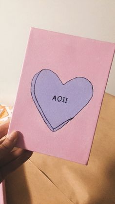 a hand holding up a card with an image of a heart on it and the word aoi written in black