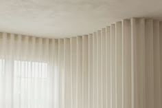 an empty room with vertical blinds on the wall