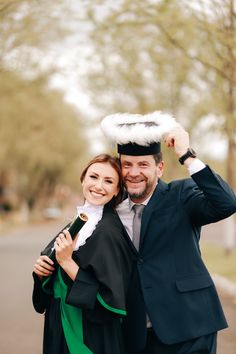 a man and woman are dressed up in graduation attire, posing for a photo with their arms around each other