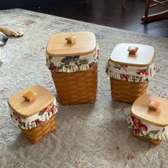 a dog laying on the floor next to three baskets with lids and handles, one for food