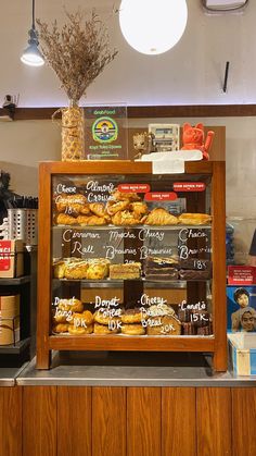 a bakery display case filled with donuts and other pastries in front of the counter