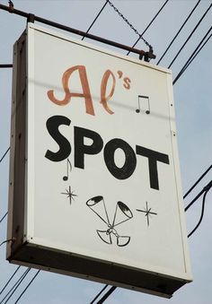 a sign that says al's spot on the side of a building with power lines in the background