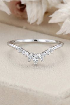 a diamond ring sitting on top of a white flower