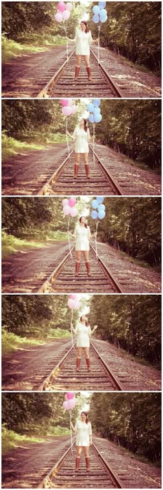 a woman is standing on the train tracks with balloons in her hand and holding onto some string