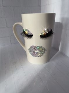 a coffee cup with glitter eyes and eyelashes on it