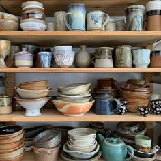 shelves filled with lots of different kinds of bowls and cups on top of each other