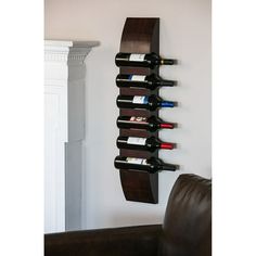 a wall mounted wine rack with several bottles on it and a leather chair in the background