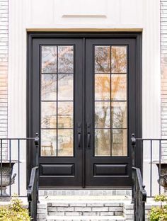 a black double door with two sidelights and steps leading up to the front door