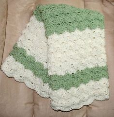 a blanket is laying on top of a bed with the covers pulled back and crocheted